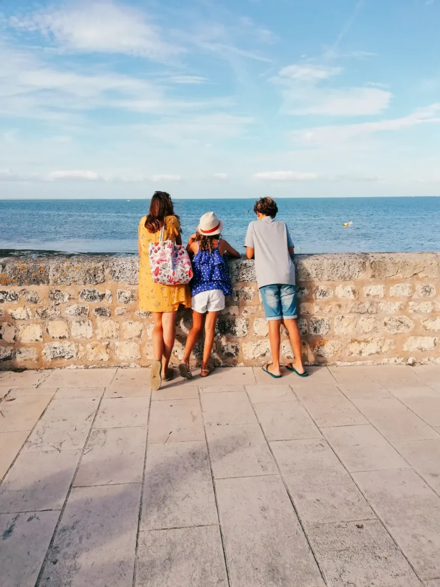 Une mere et ses enfants sur le front de mer observant l ocean 40024