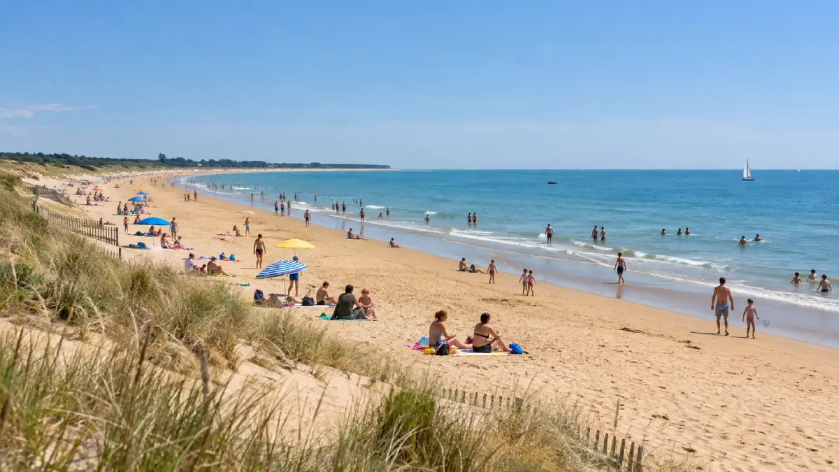 Plage de sable fin de La Tranche-sur-Mer en été avec baigneurs et parasols